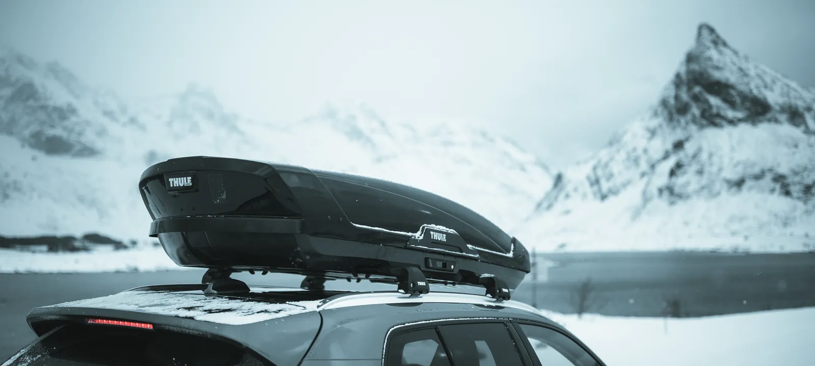 Wagen met Thule dakkoffer in berglandschap